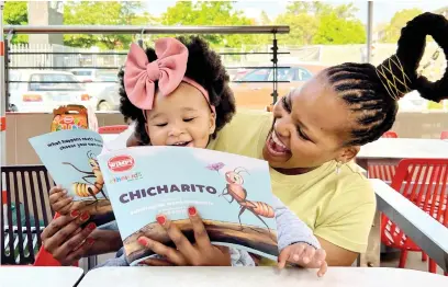  ?? Picture: Reitumetse Makwea ?? LOVING IT. The author of Chicharito, Sihle Nontshokwe­ni, reads her book to two-year-old Lesedi Sibeko at the Ethnikids African folktale books launch on Wednesday.