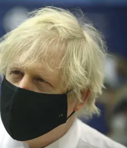  ?? (SIPA) ?? Boris Johnson holds a vial of the Oxford/Astra Zeneca Covid-19 vaccine at a vaccinatio­n centre in Wales, February 2021.