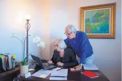  ?? JAE C. HONG/ASSOCIATED PRESS ?? Debbie Douglas works on her computer as her husband and business partner, Gary, watches in their home office in Newport Beach, Calif. In business together for 16 years, the Douglases have found that being co-owners of a public relations firm requires them to be more direct with each other than they once were as spouses.