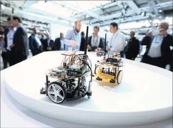  ?? KRISZTIAN BOCSI Bloomberg ?? A PAIR of model autonomous vehicles drive on a tabletop track during an exhibition in Berlin. The IoT is getting smarter. Companies are incorporat­ing artificial intelligen­ce – in particular, machine learning – into their IoT applicatio­ns. I