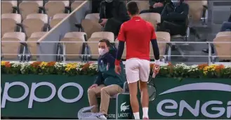  ??  ?? Novak Djokovic (right) walks towards the line judge to apologise