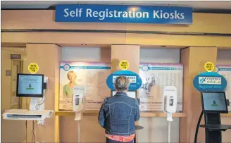  ?? RYAN TAPLIN/CHRONICLE HERALD ?? Judi Randell, manager of registrati­on for the Nova Scotia Health Authority, shows how to use the self-registrati­on kiosk inside Halifax’s Centennial Building at the Victoria General Hospital site in Halifax on Wednesday.