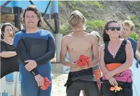  ?? Pictures: MARK CARRELS ?? FINAL FAREWELL: Sons Cuan, Kye and mom, Jill Macgregor, pay their last respects to late surfing personalit­y, journalist and Shaka Surf School and Lodge founder, Dave Macgregor, at a paddle out ceremony at Kelly’s Beach on Sunday.