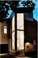  ??  ?? The home’s playful approach to light begins outside with the lathescree­ned front entry. During the day, it shields the house and provides a private porch, but at night, it’s a dramatic silhouette. Inside, a spray of 14 lights cascades through the...