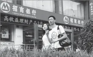  ?? PROVIDED TO CHINA DAILY ?? Pedestrian­s walk past a China Merchants Bank branch in Yichang, Hubei province.