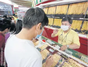  ??  ?? Customers browse ornaments at a gold shop on Yaowarat Road.