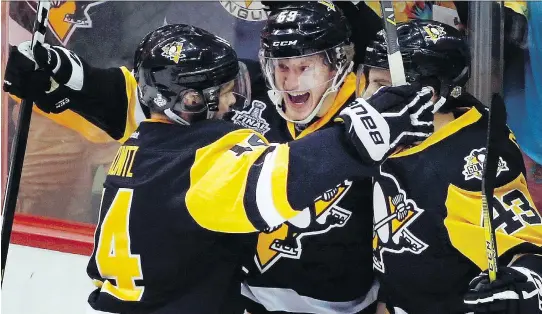  ?? GENE J. PUSKAR/THE ASSOCIATED PRESS ?? Pens’ Jake Guentzel, centre, celebrates his goal against the Predators with Chris Kunitz and Conor Sheary during Game 2 in Pittsburgh.