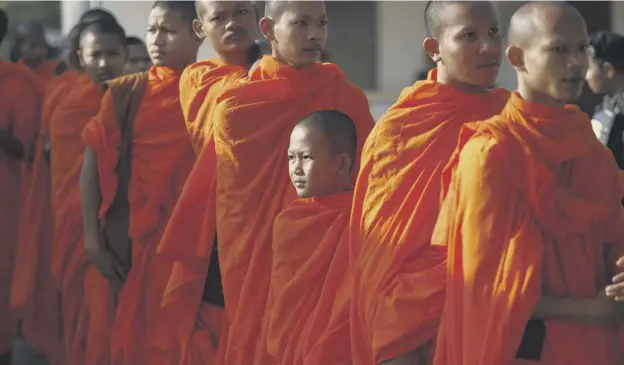  ?? PICTURE: HENG SINITH/SP ?? Cambodian Buddhist monks wait in queue to enter the courtroom before the hearings against two former Khmer Rouge senior leaders