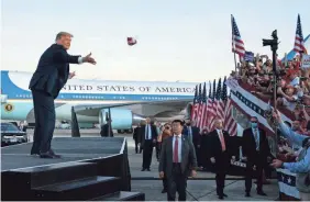  ?? EVAN VUCCI/AP ?? Trump tosses face masks into the crowd at Orlando Sanford Internatio­nal Airport on Oct. 12 in Sanford, Fla.