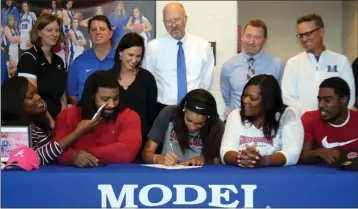  ?? Jeremy Stewart / RN-T ?? Model’s Victaria Saxton (seated, center) signs her letter of intent to play basketball at South Carolina during a ceremony Monday, November 13, 2017. Joining her are her sister, Charron Woodley (seated, from left), her father, Victor Saxton Sr., her...