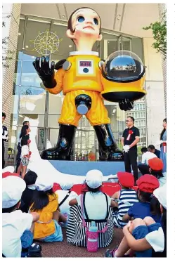  ?? — AFP ?? Here comes the sun: Children witnessing the unveiling of ‘ Sun Child’ by Yanobe at a ceremony in Fukushima.