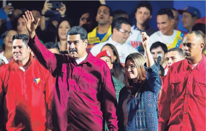  ?? AP ?? El presidente venezolano, Nicolás Maduro, acompañado por su esposa, Cilia Flores, saludó anoche a sus seguidores luego de conocer que había triunfado en las elecciones.