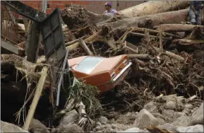  ??  ?? A car is caught in debris after flooding caused by torrential rain in Venezuela