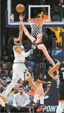  ?? AP-Yonhap ?? Houston Rockets center Alperen Sengun, center, fouls Denver Nuggets guard Jamal Murray, left, during the first quarter of an NBA game in Denver, Wednesday.