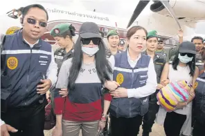  ?? APICHIT JINAKUL ?? The suspects are escorted by immigratio­n officials upon their arrival at the Police Aviation 3 in Bangkok’s Don Mueang airport.