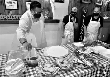  ?? COURTESY PHOTO ?? Assemblyme­mber Eduardo Garcia tries his hand Oct. 21 at crafting a pizza while George’s Pizza co-owner George McClure (far right) and an unidentifi­ed restaurant employee look on.