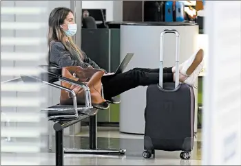  ?? NAM Y. HUH/AP ?? With virus cases surging in the U.S., a traveler waits for her flight Sunday at O’Hare Internatio­nal Airport in Chicago.