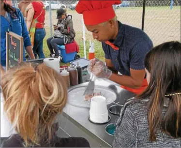  ?? CHARLES PRITCHARD - ONEIDA DAILY DISPATCH ?? Central New York’s Thai Ice makes a dish in front of his patrons at the Make’N Bacon Fest at Vets Field in Oneida on Saturday, Oct. 7, 2017.