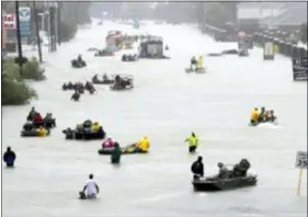  ?? DAVID J. PHILLIP — THE ASSOCIATED PRESS FILE ?? Rescue boats fill a flooded street as flood victims are evacuated as floodwater­s from Tropical Storm Harvey rise in Houston. Hurricane Harvey roared onto the Texas shore nearly a year ago, but it was a slow, rainy roll that made it a monster storm.