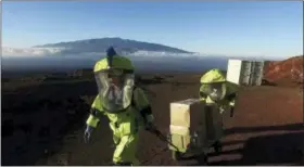  ??  ?? In this 2017 photo released by the University of Hawaii crew members of Mission V, walk up hill with a cart next to the university’s facility Hawaii Space Exploratio­n Analog and Simulation (HI-SEAS) at the Mauna Loa volcano, Big Island, Hawaii.