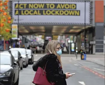  ?? Peter Byrne Press Assn. ?? BRITISH regulators’ emergency approval of a vaccine by U. S. drugmaker Pfizer and Germany’s BioNTech was hailed as a sign of hope in a country hit hard by COVID- 19. Above, a pedestrian in Manchester, England.