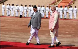  ?? — AP ?? Prime Minister Narendra Modi walks with his Nepalese counterpar­t Khadga Prasad Sharma Oli during a ceremonial reception for the latter in New Delhi on Saturday.