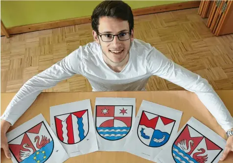  ?? Foto: Marcus Merk ?? Maximilian Braun zeigt die fünf Entwürfe für das Wappen von Waltershof­en, die es in die Endrunde schafften.