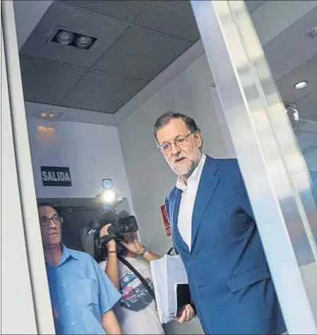  ??  ?? Mariano Rajoy, ayer a su entrada en la sala de prensa del PP, acompañado por María Dolores de Cospedal