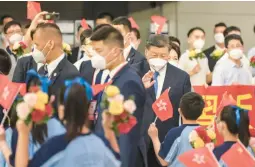  ?? HONG KONG GOVERNMENT INFORMATIO­N SERVICES ?? Chinese leader Xi Jinping waves to students waving flags as they welcomed him Thursday at a Hong Kong railway station.