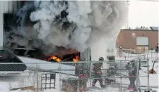 ?? GREG PENDER/The StarPhoeni­x ?? Firefighte­rs were called to a Canadian Tire warehouse fire on Friday. Here they get in position from the side of the building facing 107th Street East.