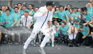  ?? Picture: REUTERS ?? WINNERS: Lewis Hamilton is sprayed with champagne as Nico Rosberg, kneeling centre, celebrates with his team after winning the Mexican Grand Prix two weeks ago. Rosberg wants to add to last year’s victory on Sunday.