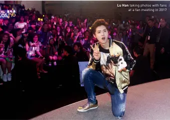  ??  ?? Lu Han taking photos with fans at a fan meeting in 2017