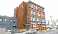  ??  ?? The Indovinas added a parking garage, left, and tower containing stairs and elevator to the 114-year-old Pittsburgh Brass Manufactur­ing Co. building in the Strip District.