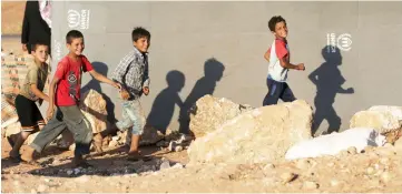  ??  ?? File photo show internally displaced boys run outside a tent in Idlib province, Syria. — Reuters photo