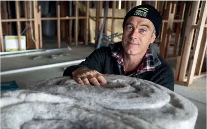  ?? BEJON HASWELL/ STUFF ?? Miles Anderson with the wool insulation he is using in his new house.