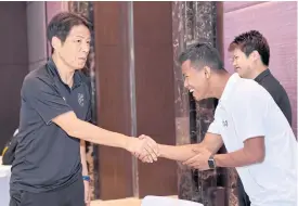  ??  ?? Thailand coach Akira Nishino, left, greets midfielder Sasalak Haiprakhon.