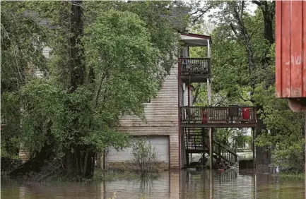  ?? Godofredo A. Vasquez photos / Houston Chronicle ?? Water from the swollen San Jacinto River on Thursday flooded residences along Lake Point Drive in Humble.