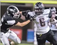  ?? / Steven Eckhoff ?? Chattooga’s Lashaun Lester (6) stiffarm’s Coosa’s Dakota Roper on a run during Friday night’s game at Coosa High School.