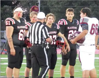  ?? TIMES photograph by Annette Beard ?? Blackhawk team captains Beau Germain (no. 61), Kamden Boyd (No. 56), Wyatt Weber (No. 37) and Britton Caudill (No. 22) meet in the center of the field for the coin toss prior to Friday night’s home game.