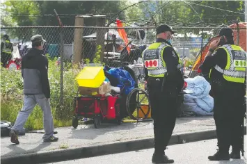  ?? — NICK PROCAYLO ?? Vancouver police attended CRAB Park on June 16 and began ordering tent city residents off the property.