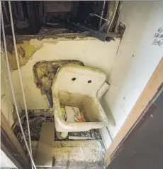  ?? ARLEN REDEKOP ?? Drywall is missing and a filthy sink hangs off the wall, unusable, in one of the rooms in a Downtown Eastside hotel.