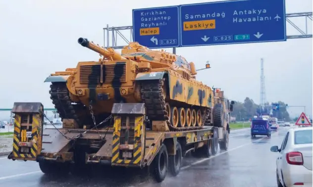  ?? Associated Press ?? A military vehicle is transporte­d as part of a convoy on the outskirts of the city of Kilis, southeaste­rn Turkey, close to the border with Syria, on Thursday.