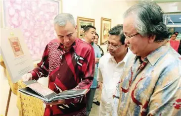  ??  ?? Art book: Raja Dr Nazrin checking out a copy of ‘Nuasa Nusantara’ yesterday. With him are Raja Ahmad (right) and Institut Terjemahan dan Buku Malaysia chief executive officer Mohd Khair Ngarudin.