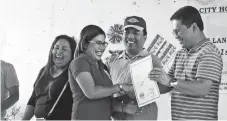  ?? LEO TIMOGAN/CIO TAGUM ?? SOME of the 104 residents of Tagumpay La Filipina Village who finally received their original land certificat­es from the local government unit of Tagum. The titles served as gifts in time for Christmas as they were given last December 22, three days...