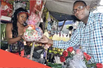  ?? ERROL CROSBY/ PHOTOGRAPH­ER ERROL CROSBY/ PHOTOGRAPH­ER ?? Dr Sedaka Donaldson buying a Valentine’s Day basket from vendor Lishaun Dunn in Half-Way Tree, St Andrew, yesterday. At LEFT: Valentine’s Day baskets for sale were aplenty across the streets of the Corporate Area, yesterday.