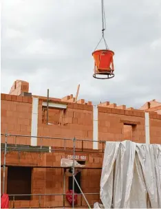  ??  ?? Der Beton für die Treppe wird per Kran und Betonkübel in das Haus transporti­ert und dort von den Maurern vorsichtig in die Schalung gegossen.