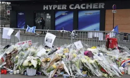  ?? Photograph: Bertrand Guay/AFP via Getty Images ?? Flowers left in tribute to the victims of the attack at the Hyper Cacher supermarke­t in Paris in 2015.