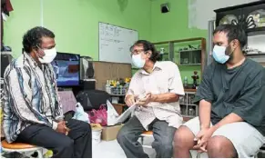  ?? – THOMAS yong/the Star ?? Please help: Vijayan showing medical documents to Sivakumar at his home in Pasir gudang, Johor. Looking on is his son who has down Syndrome.