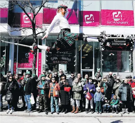  ?? ALLEN MCINNIS ?? A circus performer jumps as he dashes down Ste-Catherine St. during the St. Patrick’s Parade on Sunday.