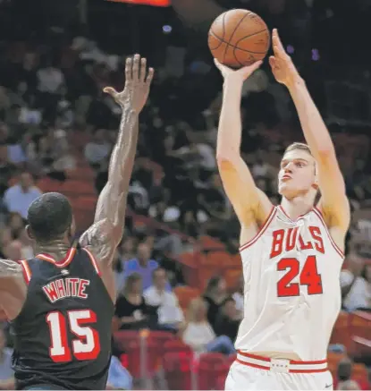  ?? | WILFREDO LEE/ AP ?? Bulls rookie forward Lauri Markkanen shoots over Heat forward Okaro White in the first half Wednesday night.